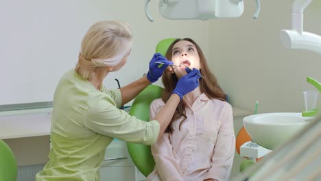 dental caries treatment in dental office. woman with open mouth in dentist chair