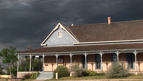 Mittlerer-Schuss-Eines-Ranchhauses-Mit-Gewitterwolken,-Die-Sich-Dahinter-Aufbauen