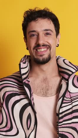 man with pink clothes and make up smiling at the camera