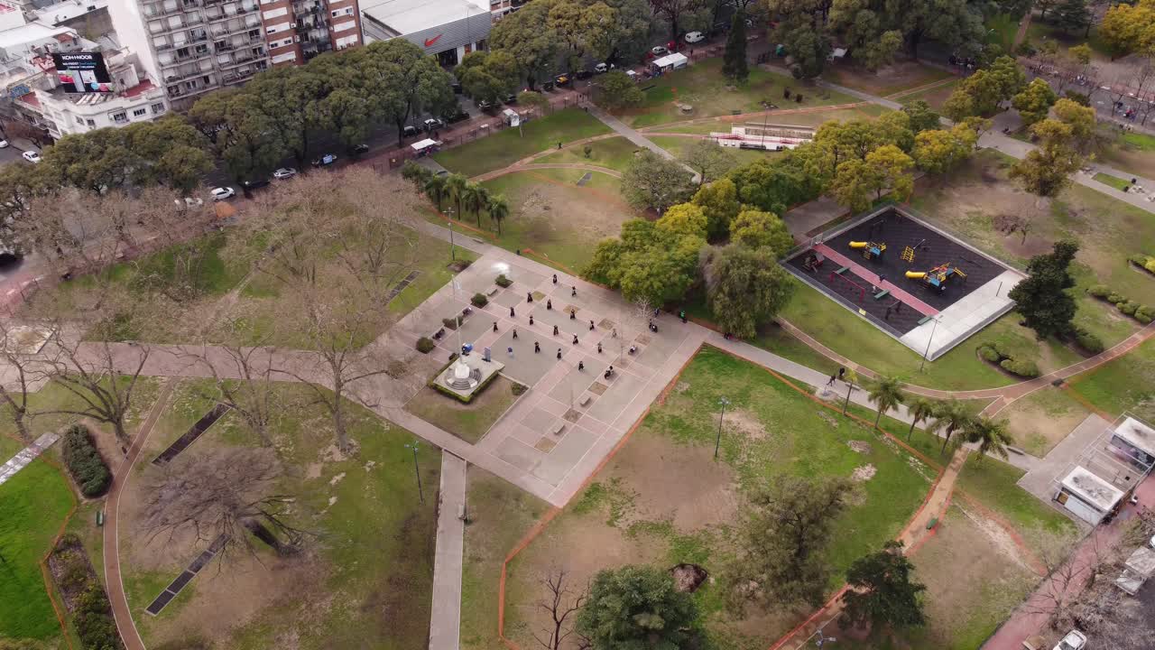 vista aérea que muestra a un grupo de ninjas practicando artes marciales en green park, 4k