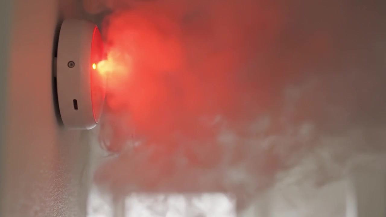 Rilevatore di fumo che si attiva in risposta al rilevamento di fumo, passando dalla modalità standby con luce verde alla modalità di allarme con luce rossa per una notifica di sicurezza immediata.