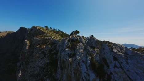 Drone-Fpv-Volando-En-Acantilados-Escarpados-En-Mallorca-Durante-El-Clima-Soleado