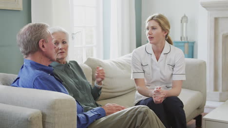 female doctor giving bad news to senior couple during home health visit