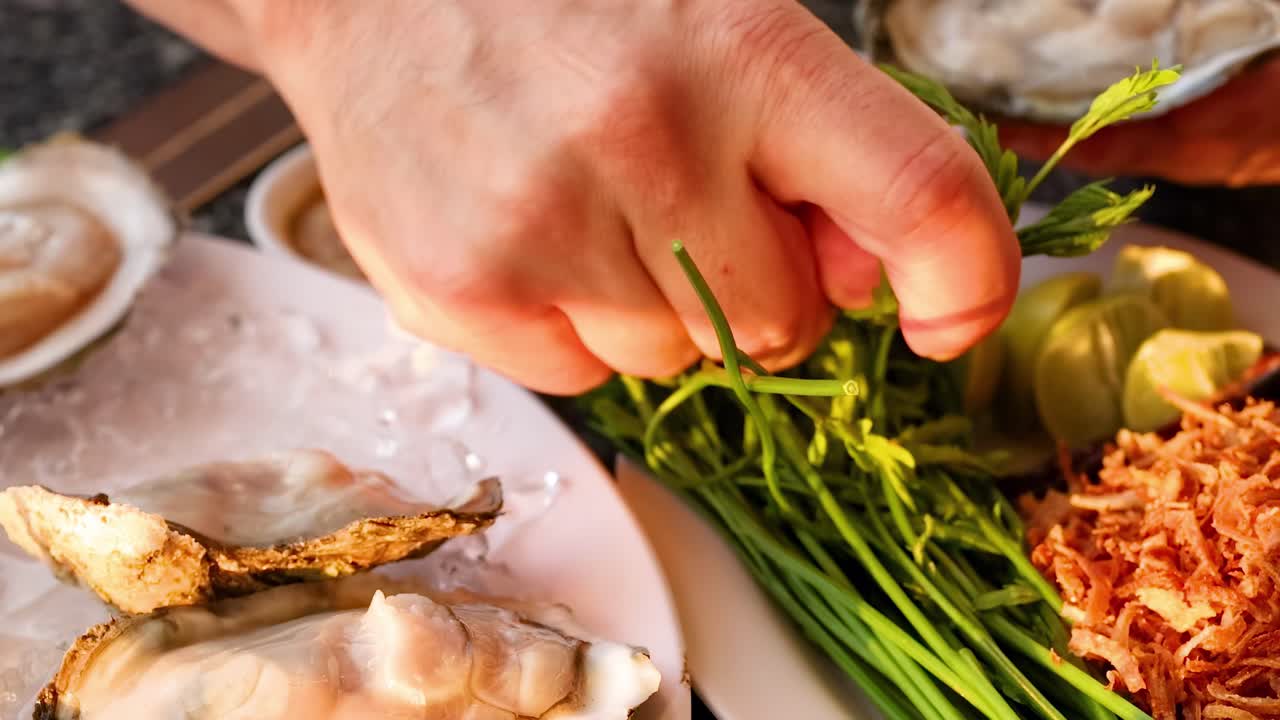 Hands delicately add herbs and spices to oysters, enhancing their flavor and presentation.