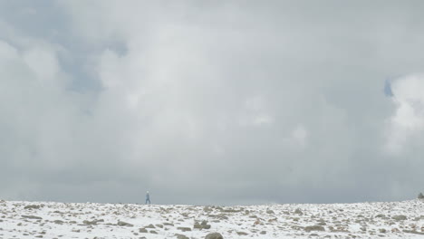 Woman-hiking-in-dramatic-scenery-of-the-Faroe-Islands-in-winter