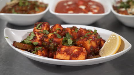 a traditional paneer tikka masala served in indian restaurant, close up slow motion orbit 4k