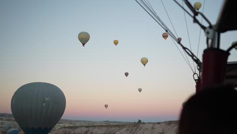 hot air balloons flying above cappadocia, turkey, aerial view from basket of another one