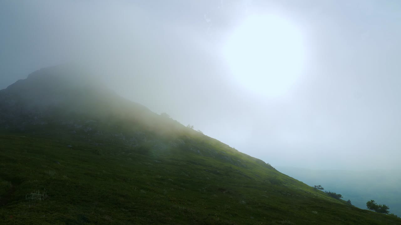 Beautiful mountain landscape. Clouds creep along the top of the mountain.