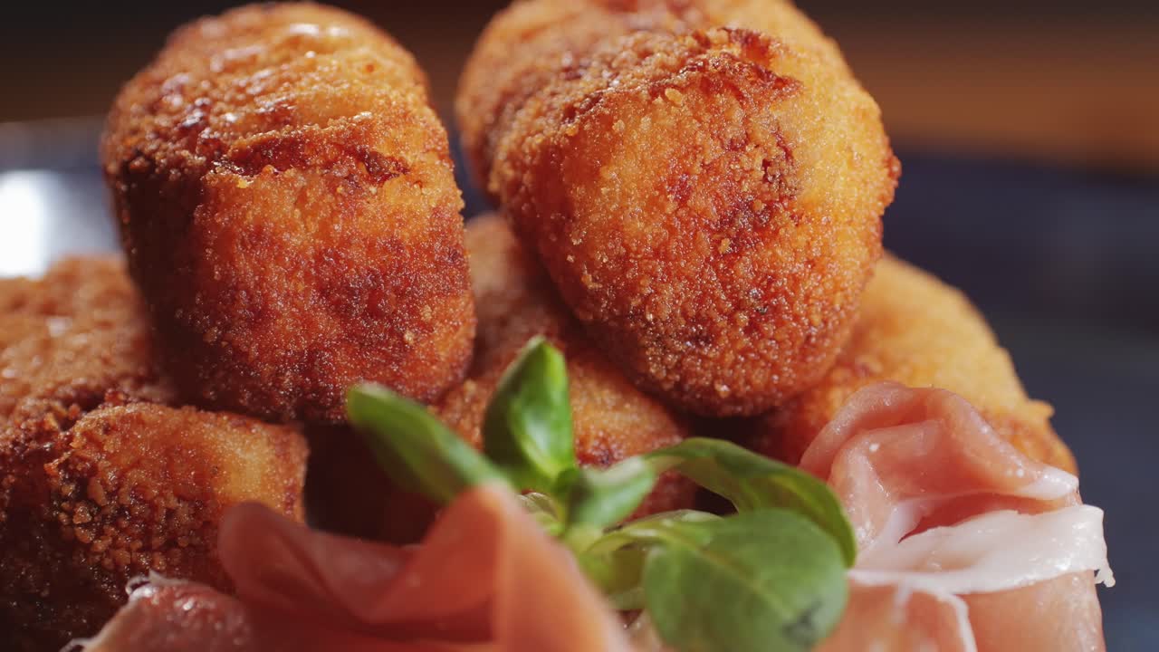 Spanish tapas, Fried portuguese croquettes close-up macro. Breaded croquette of fish, potatoes and ham. Man cooking spanish food.