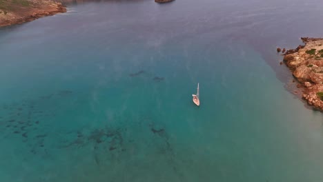 Sailing-yachts-ancor-in-coastal-waters-off-La-Vall-beach,-Menorca-Spain