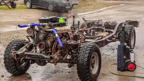 Time-lapse-of-worker-washing-the-chassis-of-four-wheeler-with-pressurized-pump