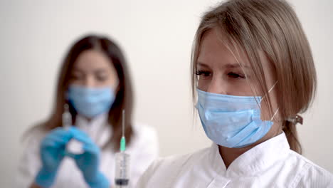 retrato de enfermera y doctora sosteniendo jeringa con vacuna para covid 19