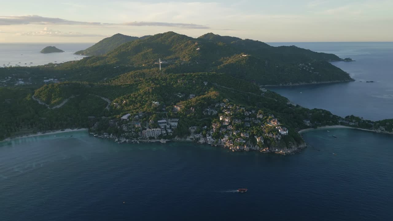 Aerial view of Koh Tao during sunset, featuring the island’s coastline, turquoise waters, and a stunning golden sky