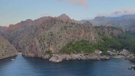 Toma-Panorámica-Lenta-Con-Drones-De-La-Sierra-De-Tramuntana-Con-Sa-Calobra-Y-Torrente-De-Pareis-Frente-Al-Mar-Mediterráneo-En-Mallorca,-España