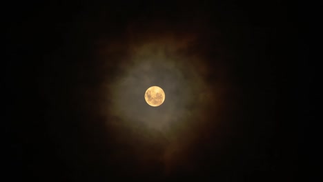 full glowing moon with clouds being blown by winds during storm at nights.