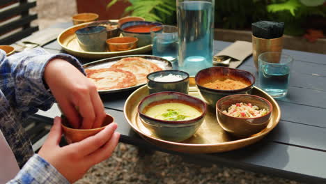 person eating indian food outdoors