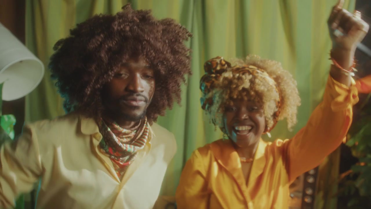 Casal Afro-Americano Animado Dançando e Sorrindo para a Câmera em Festa Retrô
