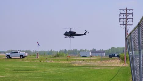 black helicopter hovering and rising in air from airfield in alberta, canada