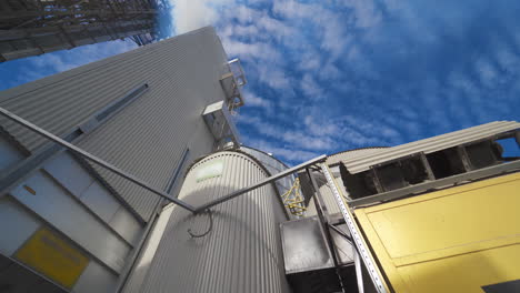 metal construction of industrial plant. industrial equipment of a modern agricultural complex for storing and processing grains against blue sky.