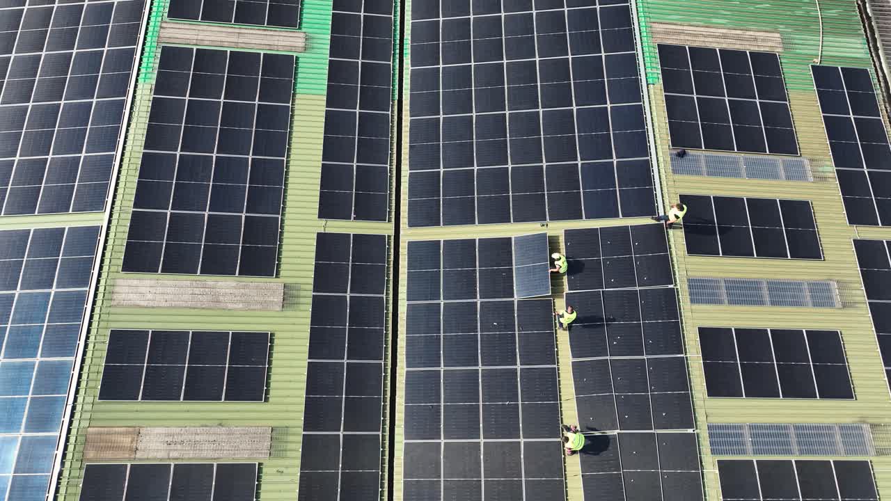trabajadores de fábrica instalando paneles solares para energía alternativa.