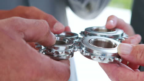 close up view of business people hands holding wheels