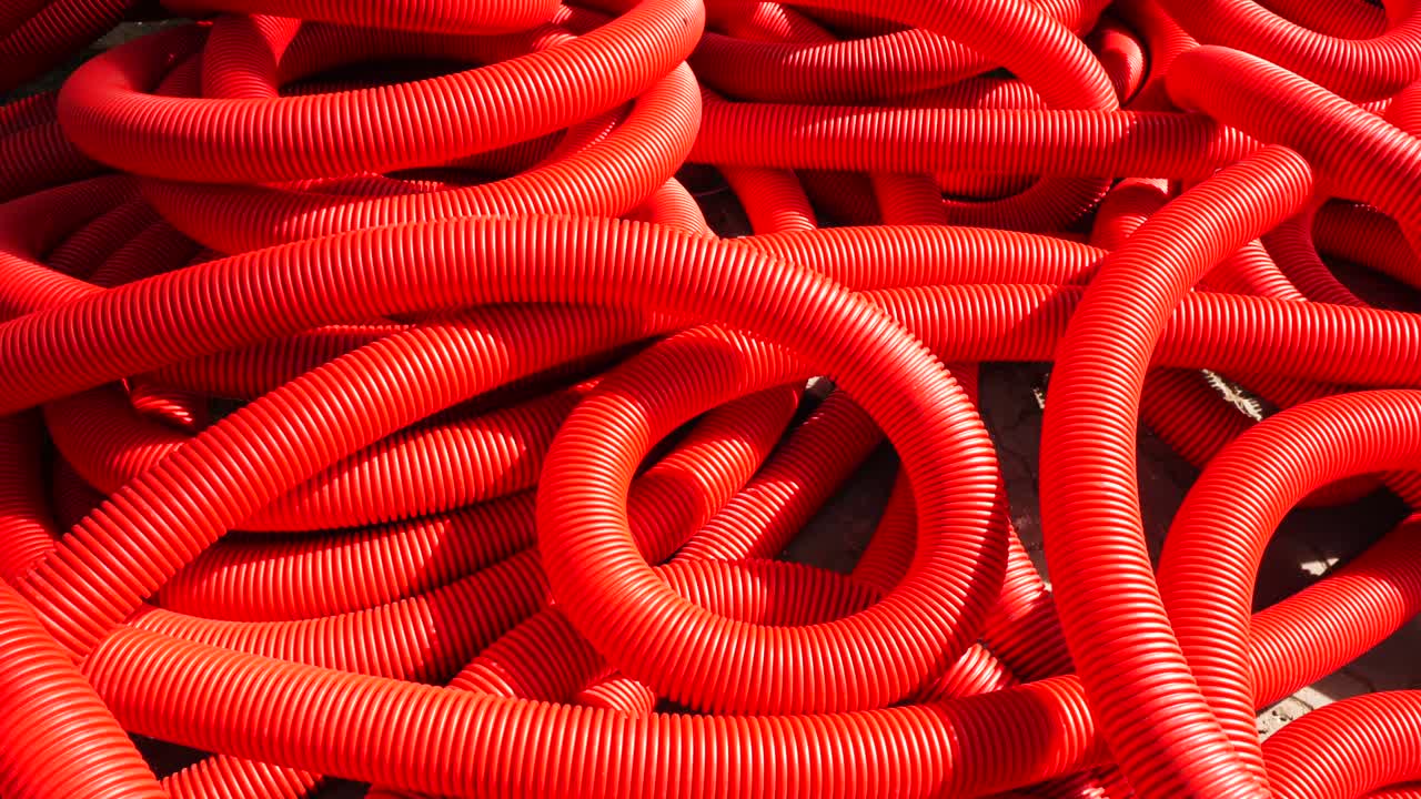 Industrial background. Plastic corrugated pipes, drainage in the roll, close-up. Red tubes or pipeline. Slow motion
