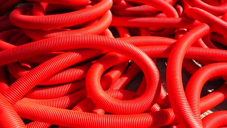 fondo industrial. tuberías onduladas de plástico, drenaje en el rollo, primer plano. tubos rojos o tubería. cámara lenta
