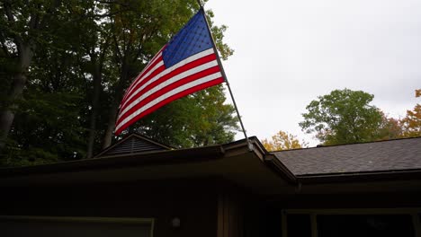 disparo de una bandera estadounidense que sopla en el viento de una tormenta de otoño en michigan, ee.uu.