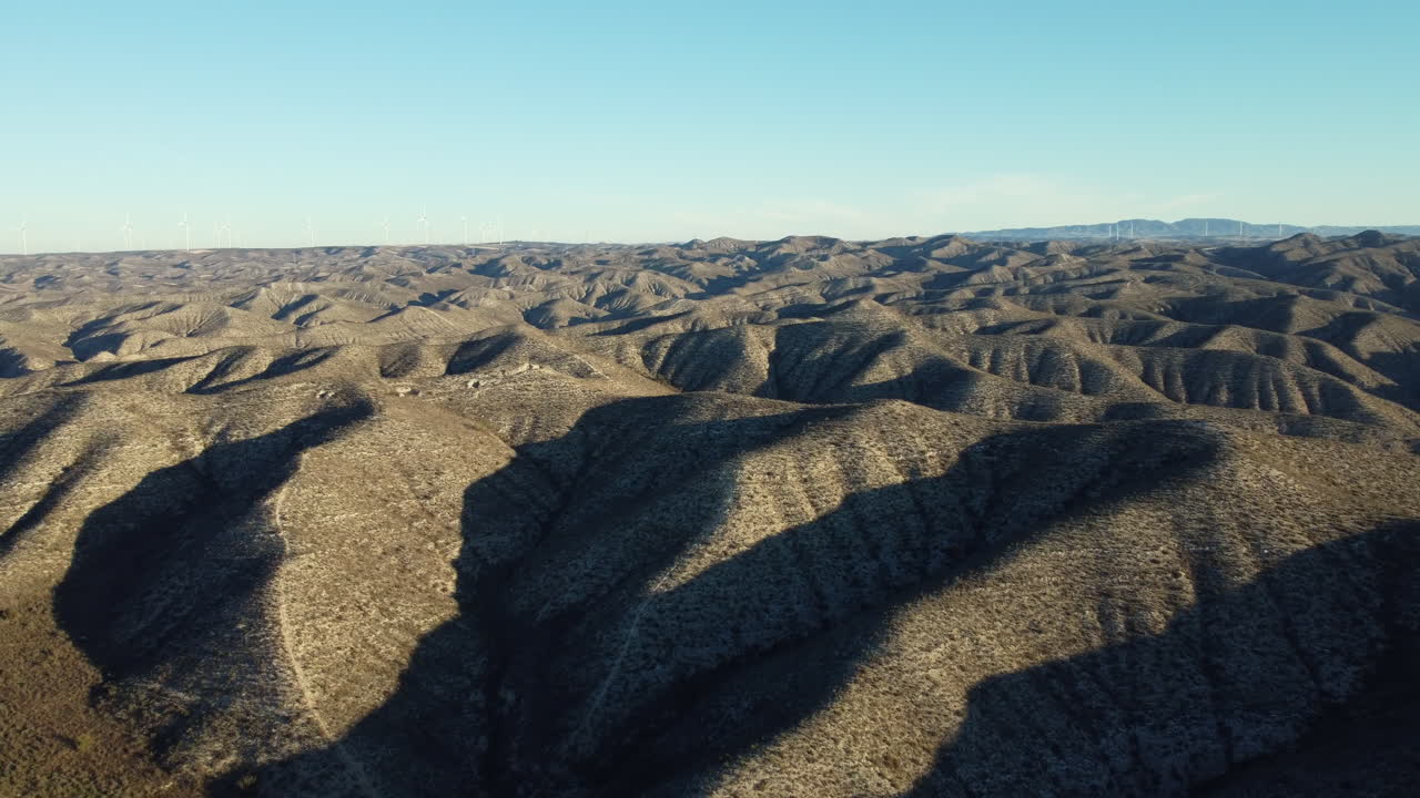 Aerial View of a Desert Mountain Range with Wind Turbines