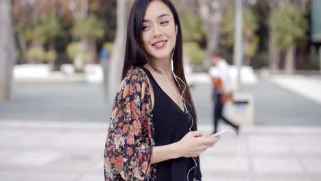 young woman walking listening to music