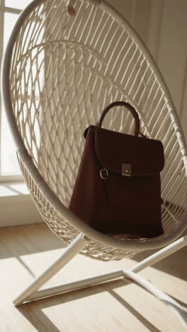 elegant brown handbag in a white woven chair