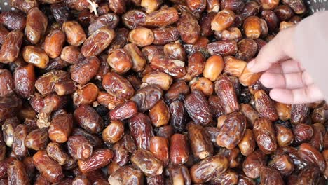 hand picking dates from a basket