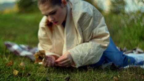 woman in a park enjoying autumn leaves