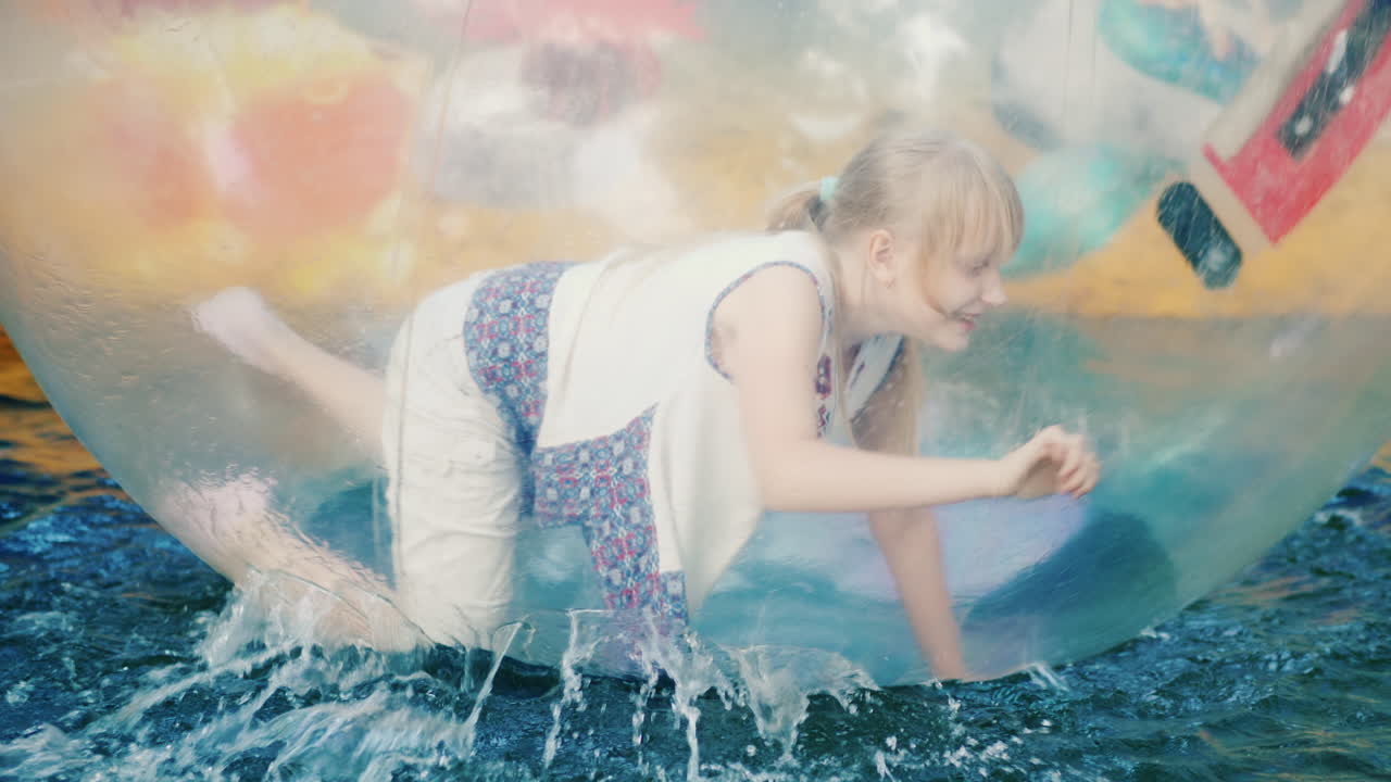 la chica se divierte dentro de la pelota que nada en la piscina - vacaciones de verano