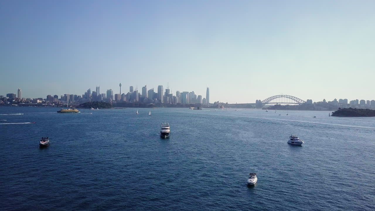Yacht e barche galleggianti nel Porto di Sydney, con il quartiere centrale degli affari (CBD) e il Sydney Harbour Bridge sullo sfondo, nel NSW, Australia.