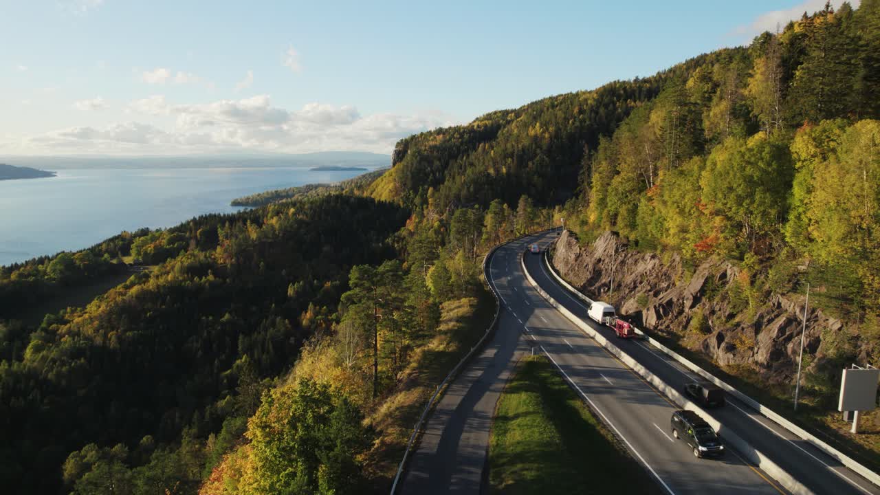 puesta de sol en la carretera entre el bosque y el lago en noruega