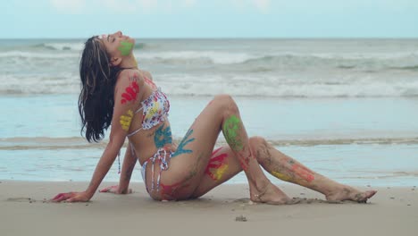 En-Un-Día-Soleado-En-El-Caribe,-Una-Joven-En-Bikini-Y-Con-Pintura-Corporal-Artística-Se-Convirtió-En-Una-Vista-Cautivadora-En-La-Playa.