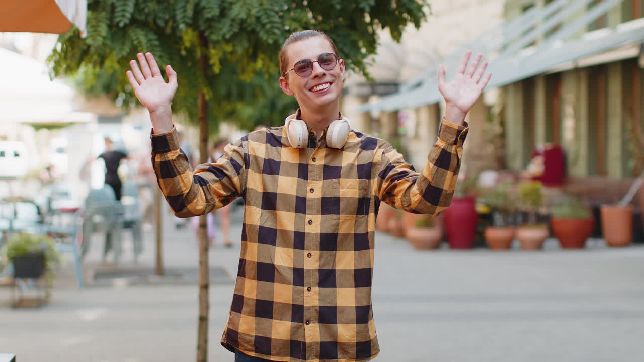 Man tourist smiling friendly at camera waving hands gesturing invitation hello hi greeting goodbye