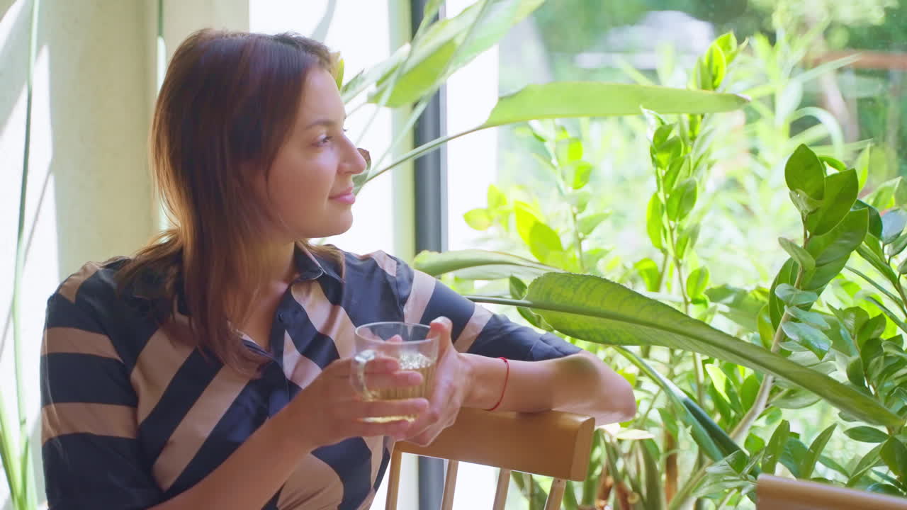 창문 에서 차를 마시며 휴식을 취하는 여자