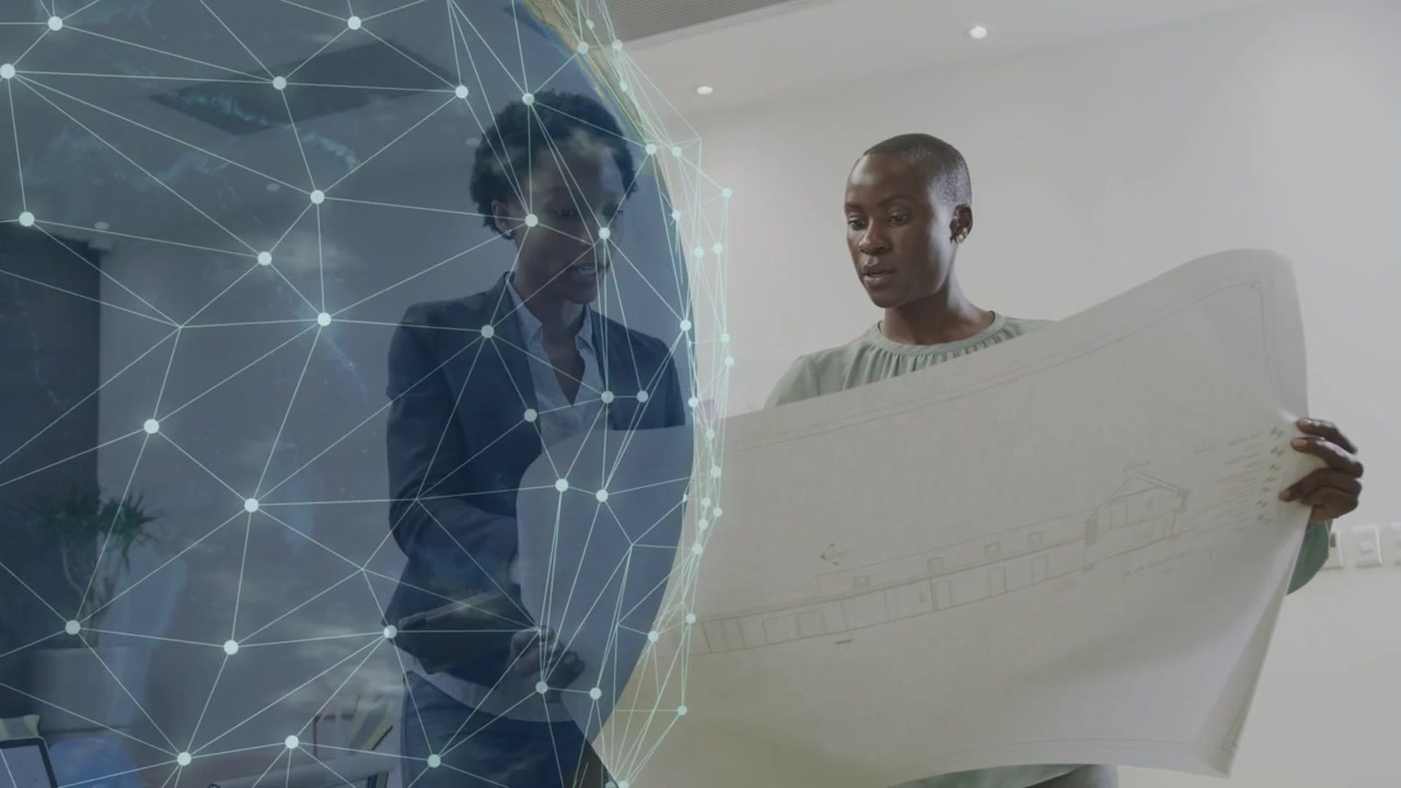 Right woman angling blueprint and activating digital globe, left woman tracing nodes for design