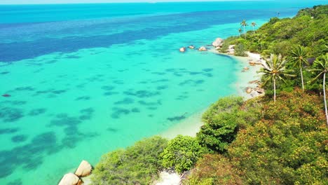 Versteckter-Exotischer-Strand-Mit-Weißem-Sand-Zwischen-Kalksteinfelsen-Und-Palmen,-Die-Von-Ruhigem,-Klarem-Wasser-Der-Türkisfarbenen-Lagune-In-Thailand-Umspült-Werden