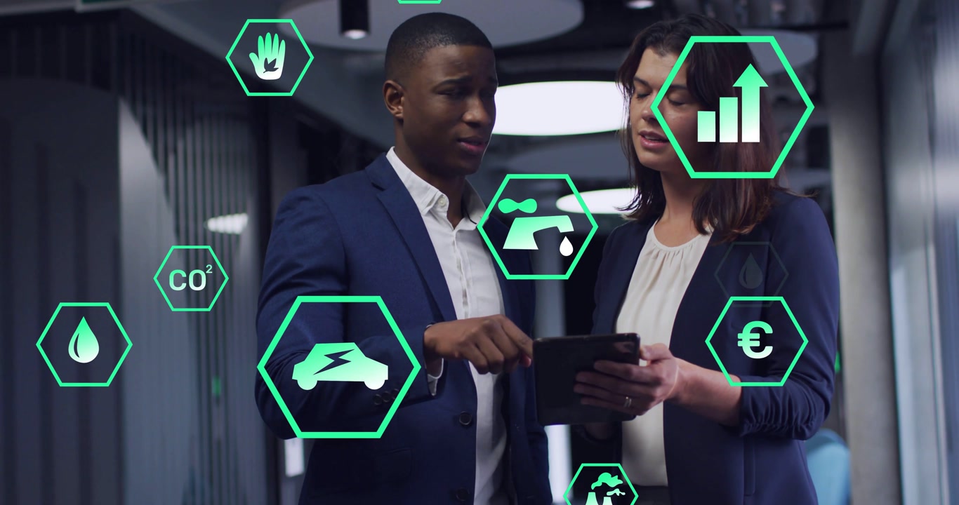 Man pointing at tablet, woman holding it, hex icons hovering and showing energy metrics for review