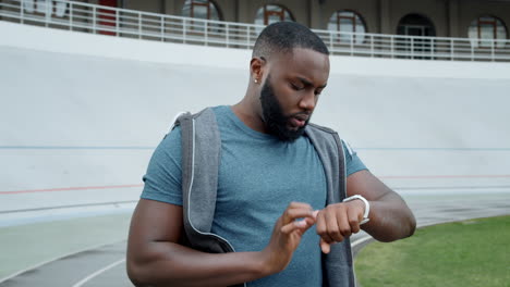 jogger using smart watch at stadium