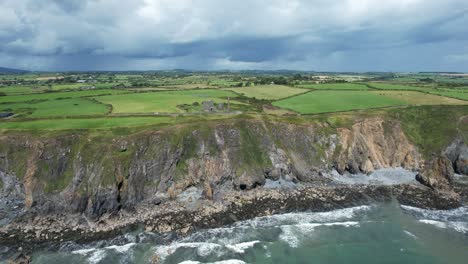 Sommersturmwellen-Schlagen-Auf-Die-Copper-Coast-Bei-Tankardstown-Ein,-Mit-Launischen-Regenwolken,-Die-Sich-Nähern-Und-An-Einem-Julimorgen-Heftige-Schauer-Bringen