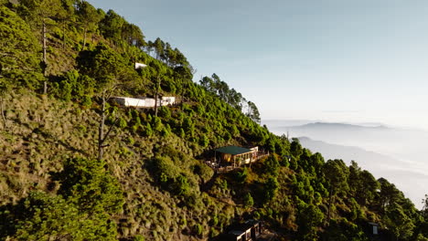drone flying towards shanty houses near summit of green inactive acatenango volcano in guatemala during sunrise