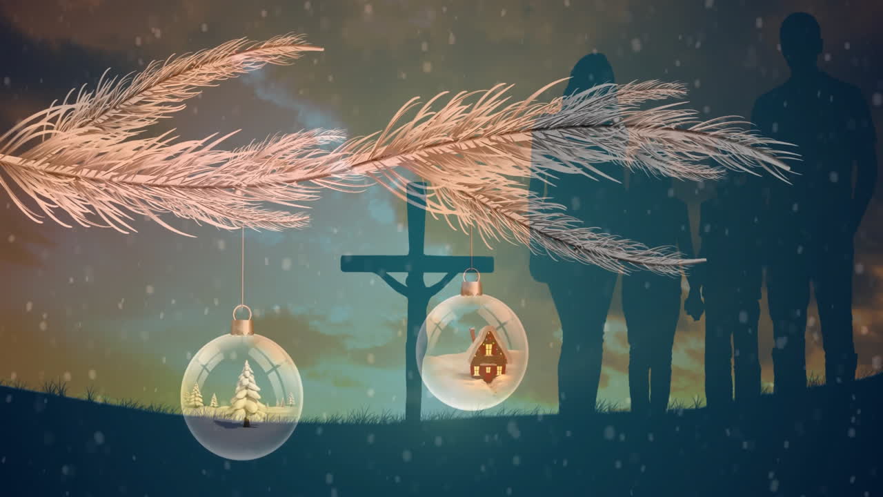 Hanging Christmas ornaments from branch with cross and silhouettes in background