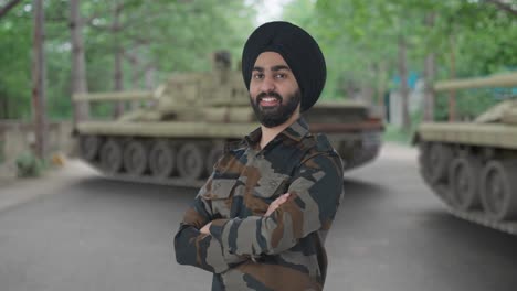 portrait of happy sikh indian army man standing crossed hands