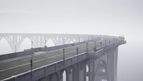 misty approach to a serene bridge crossing over an empty road