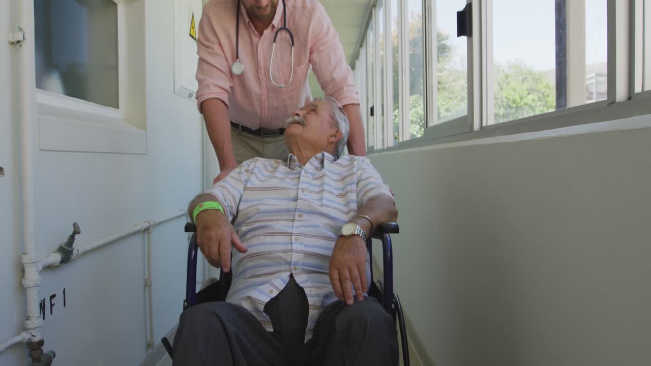 doctor caminando un hombre mayor en un corredor de la casa de jubilación