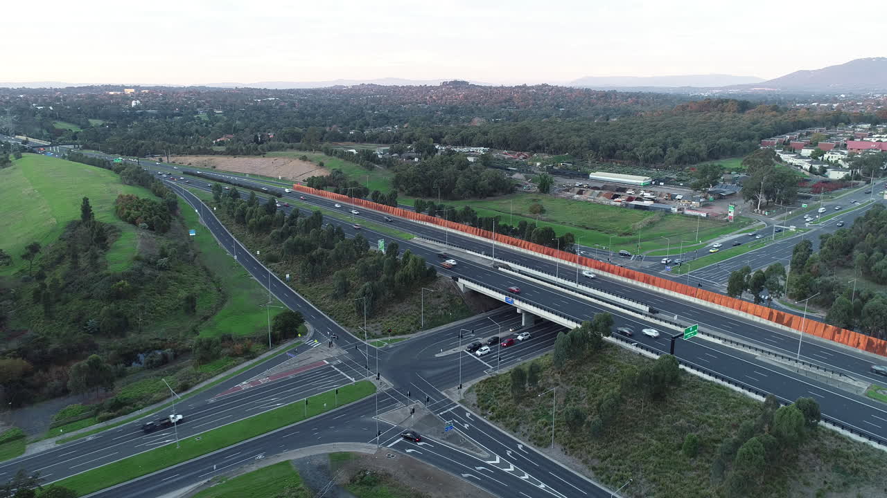Hyperlapse aerial perspective of traffic building at traffic intersection with moving carriageway on arterial above.